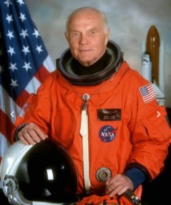 Bro. John Glenn poses with his astronaut suit and helmet