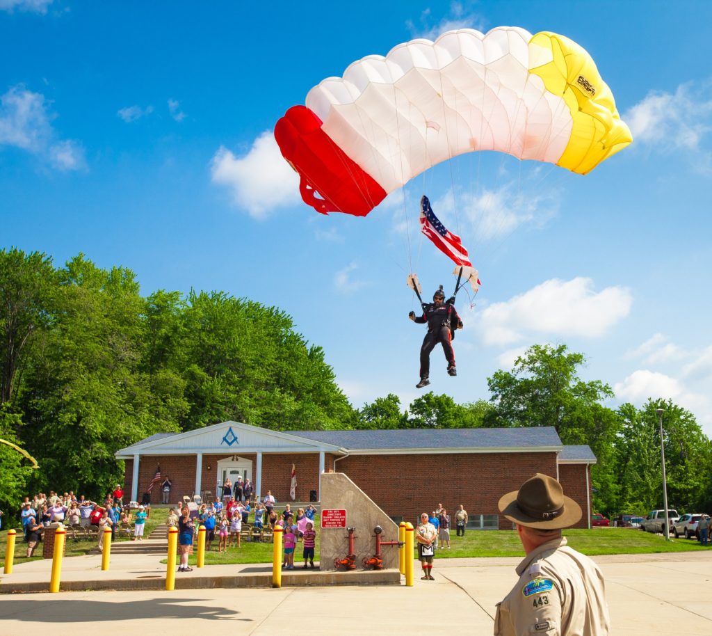 Bro. Mike Elliott, president of the All Veteran Parachute Team, retired US Army Sergeant First Class, and Prince Hall Mason parachutes into the J.B. Covert Lodge Annual Flag Retirement Event carrying a United States flag