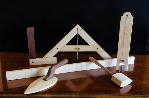 Six craftsmen tools arranged on a table.