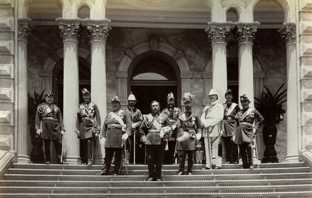 King Kalākaua and staff pose on ʻIolani Palace steps. 