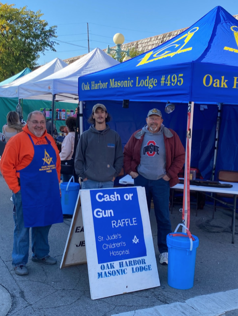 Image of 3 men at a fair raising money.