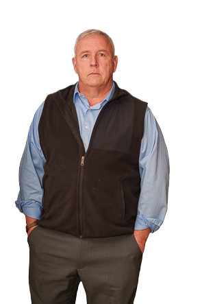 A man wearing a brown vest and blue button down shirt looking at a camera.